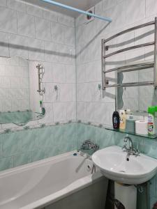 y baño con lavamanos, bañera y lavamanos. en Aparthotel VictoryHome, en Krivoy Rog