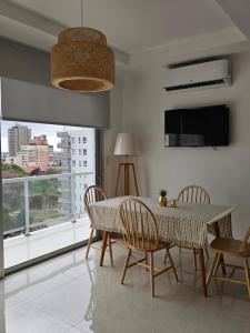 a dining room with a table and chairs and a large window at Rio Parana alta Vista in Corrientes