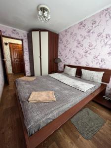 1 dormitorio con 1 cama grande y papel pintado de color púrpura en Aparthotel VictoryHome, en Krivoy Rog