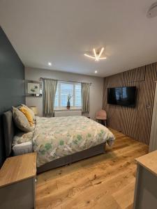 1 dormitorio con 1 cama y TV en En-suite Double Room - Private Entrance & Free Parking, en West Drayton