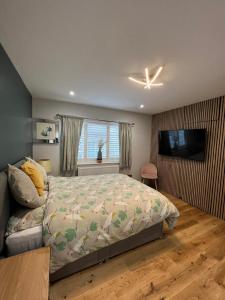 1 dormitorio con 1 cama y TV de pantalla plana en En-suite Double Room - Private Entrance & Free Parking en West Drayton