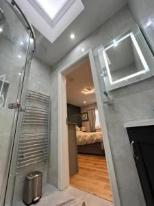 a bathroom with a shower and a room with a bed at En-suite Double Room - Private Entrance & Free Parking in West Drayton