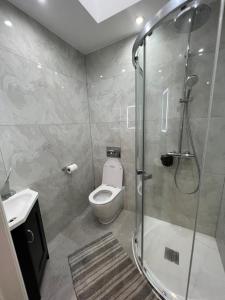 a bathroom with a toilet and a glass shower at En-suite Double Room - Private Entrance & Free Parking in West Drayton