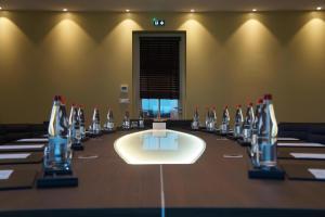 - une salle de conférence avec une grande table et des bouteilles de vin dans l'établissement Château d'Augerville Golf & Spa Resort, à Augerville-la-Rivière