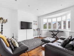 a living room with a couch and a table at Modern Four bedroom house in Enfield