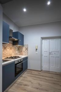 cocina con armarios azules y puerta blanca en Il Rosone - Rooms&Apartments, en Alatri