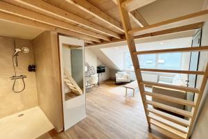 ein kleines Apartment mit einer Treppe und einem Wohnzimmer in der Unterkunft Maison avec 4 suites & Rooftop - Place Saint Paul in Lüttich
