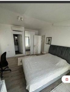 a bedroom with a large bed and a chair at Deniz manzaralı, sessiz konforlu in Dikili