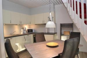 a kitchen with a wooden table and chairs in a room at Tante Maaß in Flensburg