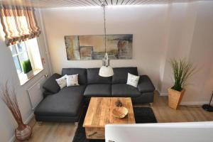 - un salon avec un canapé noir et une table dans l'établissement Tante Maaß, à Flensbourg