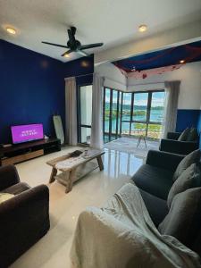 Una sala de estar con un sofá y un televisor. en Mari Mari Homestay - IMAGO THE LOFT, en Kota Kinabalu
