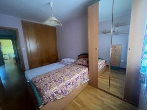 Dormitorio pequeño con cama y espejo en Casa grande con gran jardín privado, en Quicena
