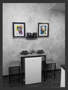 a table with two chairs and two pictures on the wall at Grazioso Monolocale Acquario a 100m free WI-FI in Genova