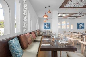 a dining room with tables and chairs and windows at Sahara Sunset in Benalmádena