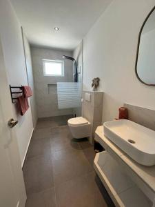 Łazienka z białą toaletą i umywalką w obiekcie Villa Sol A Luna - Mambo Beach w mieście Willemstad