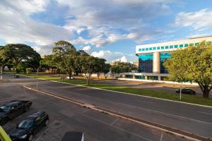 a street with two cars parked in front of a building at Asa Norte, Brasília - NOR in Brasilia