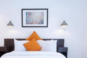 a bedroom with a bed with orange and white pillows at Blue Sky 2 Bed At Cantonments in Cantonments +55 photos
