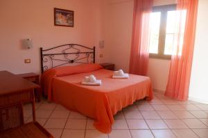 a bedroom with a bed with two towels on it at Agriresidence Ninea - First row with seaview in Capo Vaticano