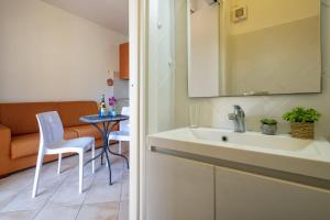 baño con lavabo y mesa con silla en Baia delle mimose 2, en Badesi