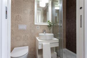 ein Badezimmer mit einem Waschbecken, einem WC und einem Spiegel in der Unterkunft Pearl House Porta Romana in Mailand