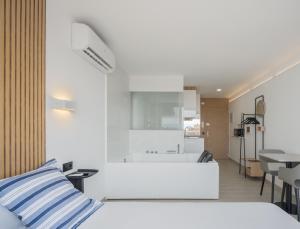 een witte slaapkamer met een bed en een keuken bij Ephemeral Holidays P.5 - Hidromasaje in Empuriabrava