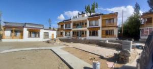 una casa in costruzione di fronte a un edificio di gultuk home stay a Leh