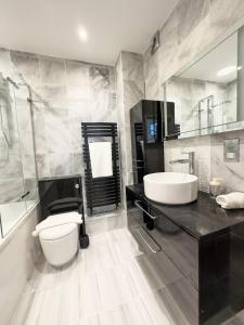 uma casa de banho com um lavatório, um WC e um espelho. em Garden flat in period property Centrally located em Bath