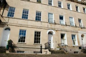 um edifício antigo com portas e janelas brancas em Garden flat in period property Centrally located em Bath