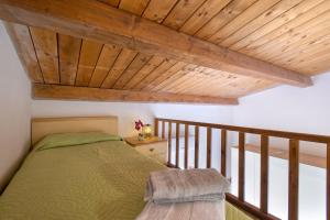 1 dormitorio con cama y techo de madera en Baia delle mimose 2, en Badesi