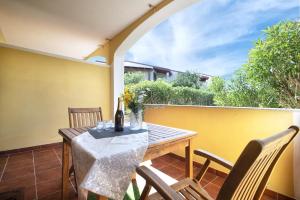 patio con mesa y sillas en el balcón en Baia delle mimose 2, en Badesi
