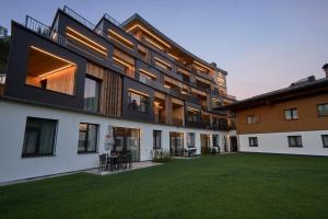 an external view of a building with a yard at Landhaus Saalbach - Joker card included in summer in Saalbach-Hinterglemm