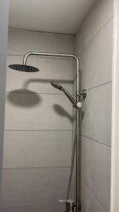 a shower with a shower head in a bathroom at Hostal low cost in Santiago