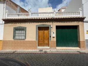 a house with a green and brown door on a street at La casita del pueblo in Molvízar