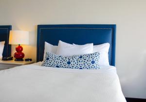 un letto con testiera blu e un cuscino sopra di Dunes Suites Oceanfront a Ocean City