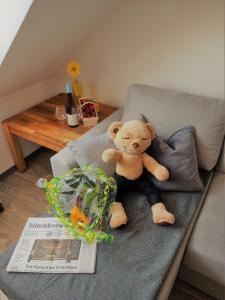 a stuffed teddy bear sitting on a couch at Gästequartier Turmblick ruhig aber zentral mit Garten in der Altstadt von Coswig Anhalt in Coswig