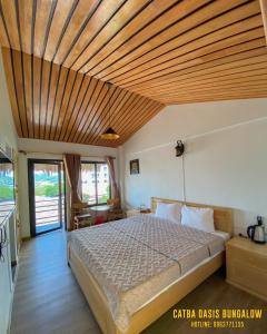 a bedroom with a bed with a wooden ceiling at Catba Oasis Bungalows in Cat Ba