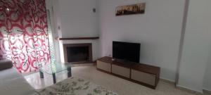 sala de estar con TV y chimenea en Casa Gazules, en Alcalá de los Gazules