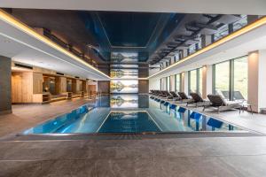 una piscina con sillas en un edificio en Thermal-Badhotel Kirchler en Tux