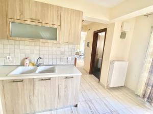 a kitchen with wooden cabinets and a sink at Alba Mare Kallithea in Kallithea Halkidikis