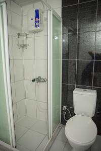 een badkamer met een douche en een wit toilet bij SARAY APART OTEL in Alanya