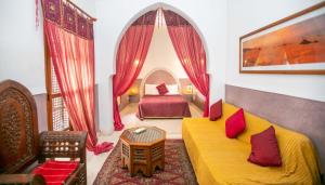 a living room with a yellow couch and a bed at Riad Marélia in Marrakesh