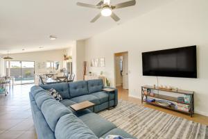 a living room with a blue couch and a flat screen tv at Stunning Phoenix Vacation Rental with Private Pool! in Phoenix