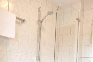 um chuveiro com uma porta de vidro na casa de banho em Ferienwohnung Merkurblick em Gernsbach