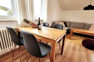 een woonkamer met een houten tafel en stoelen bij Ferienwohnung Merkurblick in Gernsbach