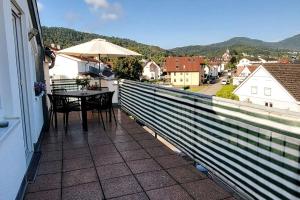 een balkon met een tafel en een parasol bij Ferienwohnung Merkurblick in Gernsbach