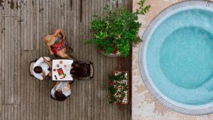 una vista dall'alto di un uomo seduto a un tavolo accanto a una piscina di Hotel Limone a Limone sul Garda