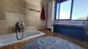 a bathroom with a bath tub and a window at Conacul Alb, prilej de vacanță 