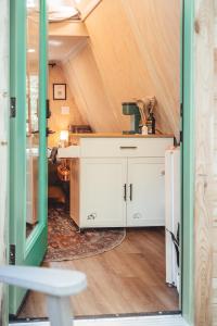 una habitación con un armario blanco en una casa pequeña en The Green Glamping Getaway, en Rockbridge