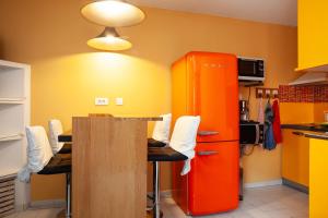 eine Küche mit einem roten Kühlschrank sowie einem Tisch und Stühlen in der Unterkunft T2 Centre Ville Rénové Climatise in Bandol