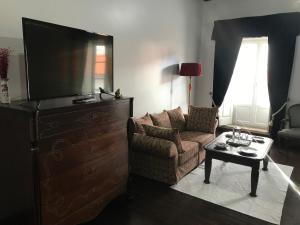 a living room with a couch and a tv and a table at Solar de Santa Maria in Bragança